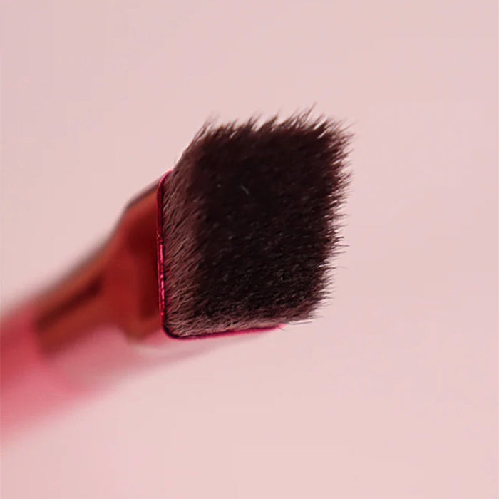 Close-up of angled eyebrow brush for concealer with soft dense bristles and pink handle