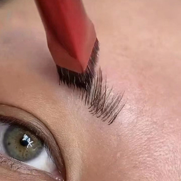 Close-up of angled eyebrow brush for concealer shaping natural eyebrow hairs