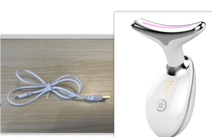 White EMS wrinkle remover device with curved head and USB charging cable on wooden surface