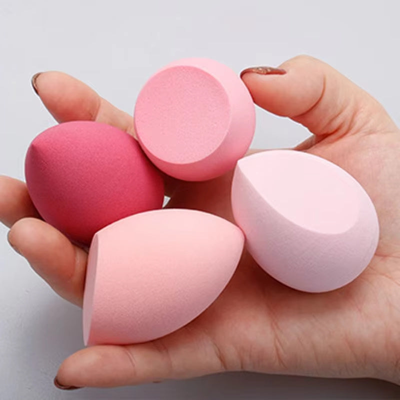 Hand holding four different shades of pink makeup blending sponge for smooth foundation application